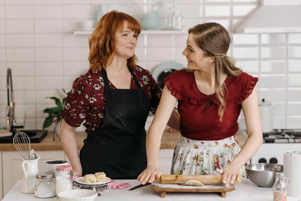 Élodie Martin with her mother, a French home cook in New York, Looking at her mother and smiling.