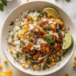 Street corn chicken rice bowl with grilled corn, seasoned chicken, and lime crema over rice
